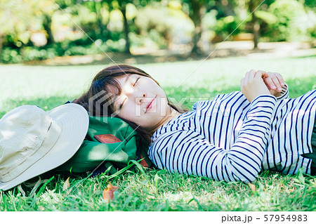 芝生に寝転がる女性の写真素材