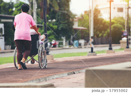 Senior couple with wheelchair in city Senior couple with wheelchair in city 57955002