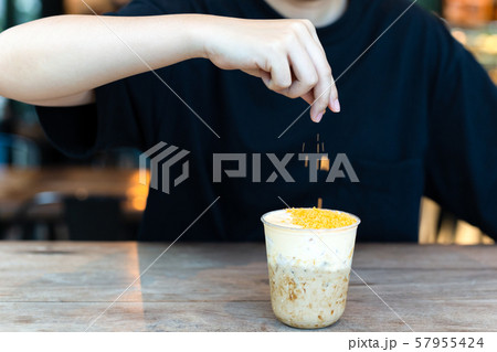 Barista making iced milk tea with salty egg at cafe. Barista making iced milk tea with salty egg at cafe. 57955424