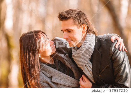 Happy family walking in autumn park on sunny fall day 57957230
