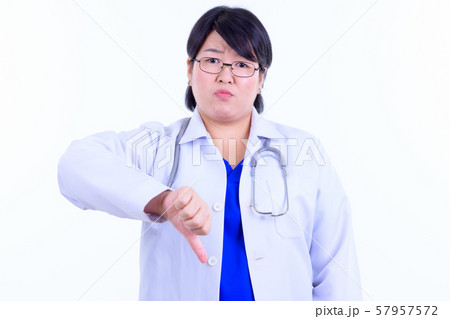 Stressed overweight Asian woman doctor giving thumbs down 57957572