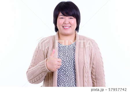 Happy overweight Asian woman giving thumbs up for winter Happy overweight Asian woman giving thumbs up for winter 57957742