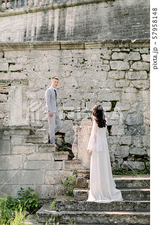 Romantic outdoor wedding portrait of the gorgeous newlywed Chinese couple standing on the stairs of 57958148
