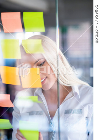 business, startup, planning, management and people concept - happy woman writing on stickers at business, startup, planning, management and people concept - happy woman writing on stickers at 57959061