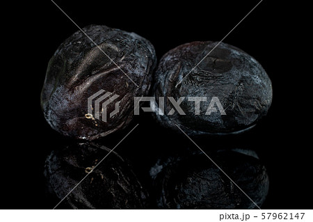 Drying dark plum isolated on black glass Drying dark plum isolated on black glass 57962147