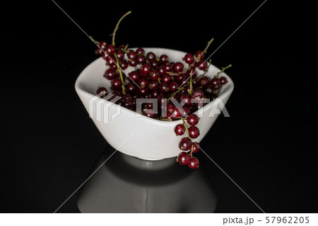 Fresh dark redcurrant isolated on black glass 57962205