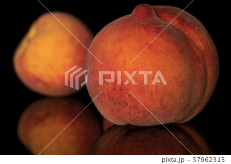 Fresh fuzzy peach isolated on black glass Fresh fuzzy peach isolated on black glass 57962313