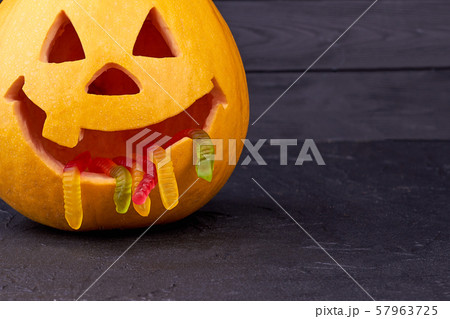 Jack-O-Lantern with gummy worms. 57963725