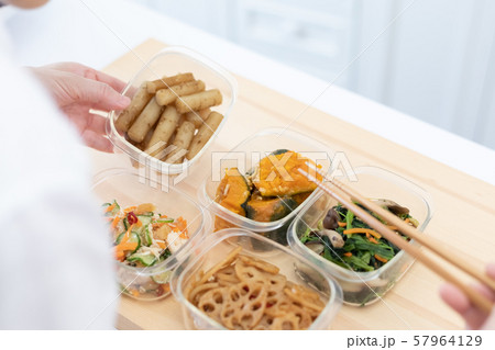 常備菜を詰める主婦の手元 57964129
