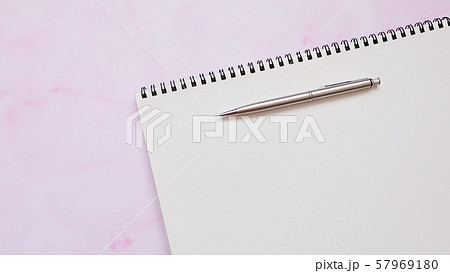 A blank spiral sketch book with a mechanical pencil, on a pink surface. 57969180