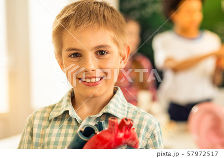 Pleased little male person looking straight at camera 57972517