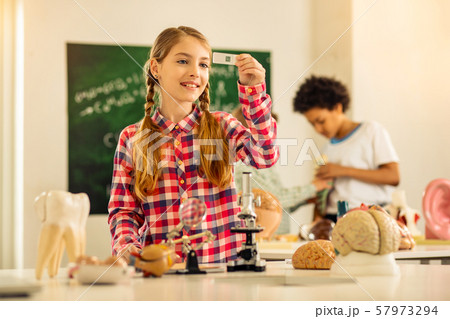 Pleased blonde girl studying with her classmates Pleased blonde girl studying with her classmates 57973294