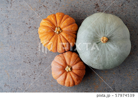 Colorful orange and mint green pumpkins on gray background, top view. Copy space for text. Thanksgiving food preparations. Autumn harvest 57974539
