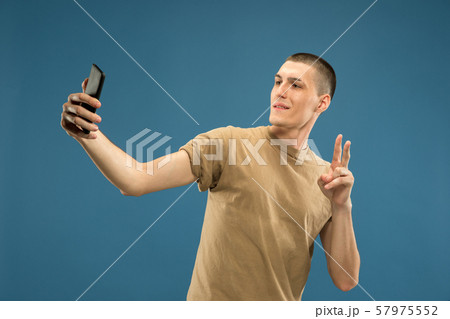 Caucasian young man's half-length portrait on blue background 57975552