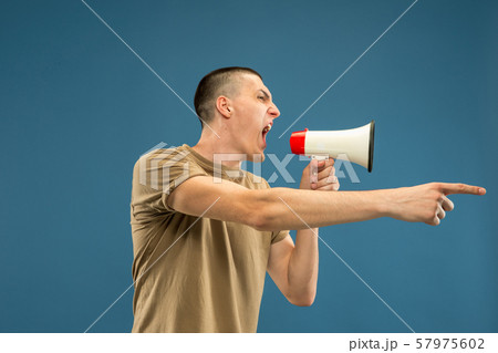 Caucasian young man's half-length portrait on blue background 57975602