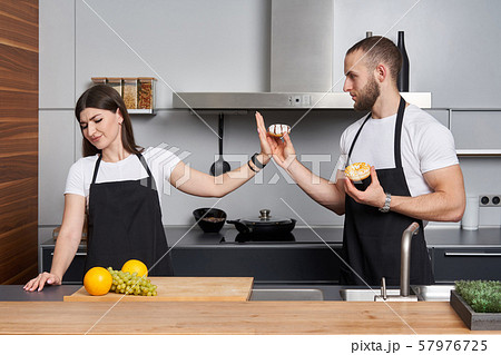 Young family in the kitchen with vegetables Young family in the kitchen with vegetables 57976725
