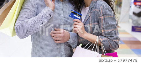 Easy shopping. Couple with credit card and paper bags Easy shopping. Couple with credit card and paper bags 57977478