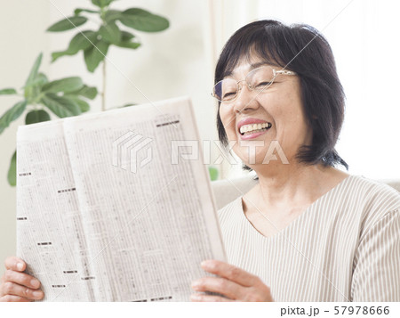 新聞の株式欄を見るシニア女性 新聞の株式欄を見るシニア女性 57978666