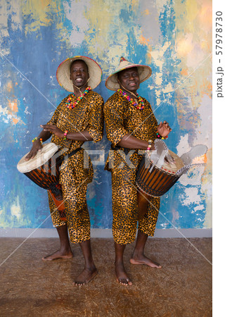A group of people in traditional african costumes playing jembe drums A group of people in traditional african costumes playing jembe drums 57978730