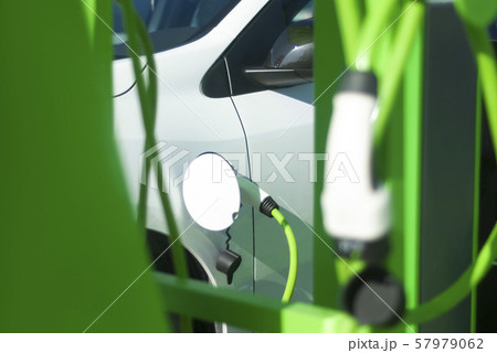 Electric car battery charging on charge station. Eco-friendly new generation gas station. Electric car battery charging on charge station. Eco-friendly new generation gas station. 57979062