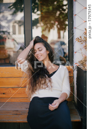 Young beautiful happy woman with long curly hair 57979345