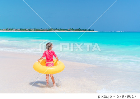 Adorable little girl having fun on the beach 57979617