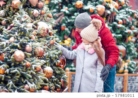 Little happy girl near fir-tree branch in snow for new year. Little happy girl near fir-tree branch in snow for new year. 57981011