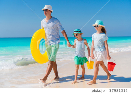 Family of dad and kids walking on white tropical beach on caribbean island with beach toys. Family Family of dad and kids walking on white tropical beach on caribbean island with beach toys. Family 57981315
