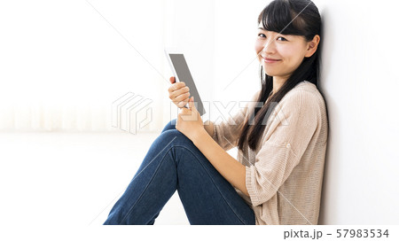 タブレットを見て微笑む女性 57983534