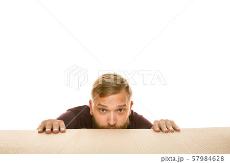 Young man opening the biggest postal package isolated on white 57984628