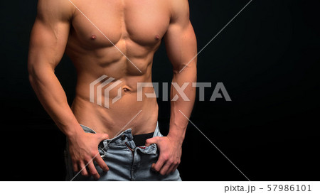 Sexy muscular man isolated on dark background Sexy muscular man isolated on dark background 57986101