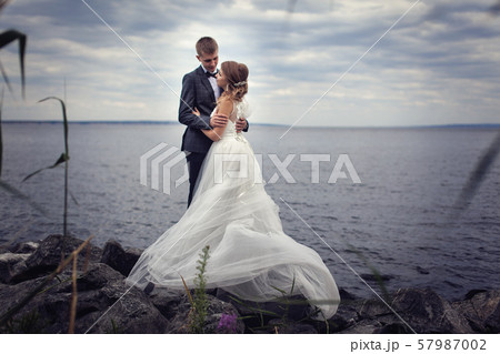 A pair of young newlyweds on the stones by the big river 57987002