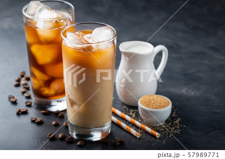 Two glasses of cold coffee on a dark background. Two glasses of cold coffee on a dark background. 57989771