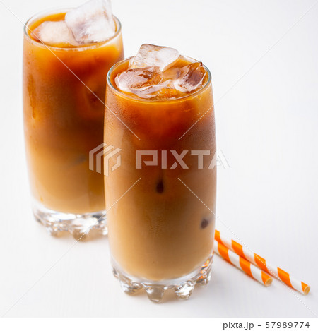 Ice coffee in a tall glass with cream. 57989774