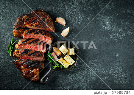 Steak ribeye, grilled with pepper and garlic. 57989784