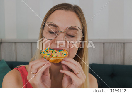 Girl in a cafe eats sweet and fresh desserts. 57991124