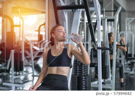 Beautiful young woman drinks water in gym. Sports Beautiful young woman drinks water in gym. Sports 57994682