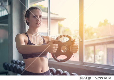 Young woman weightlifter lifting bench press Young woman weightlifter lifting bench press 57994818