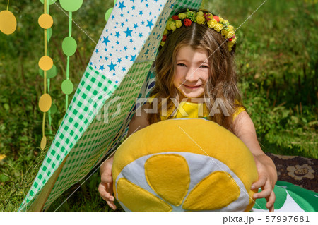 Young girl with pillows oranges in tent in park Young girl with pillows oranges in tent in park 57997681