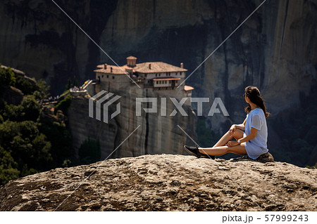 tourist woman sitting on the top of mountain on beautiful clif tourist woman sitting on the top of mountain on beautiful clif 57999243