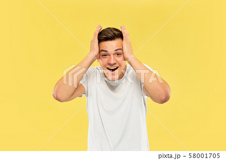 Caucasian young man's half-length portrait on yellow background 58001705