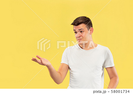 Caucasian young man's half-length portrait on yellow background Caucasian young man's half-length portrait on yellow background 58001734