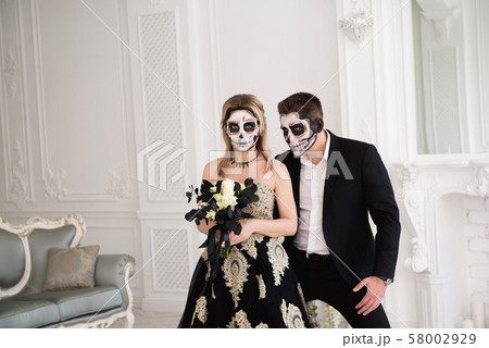 Couple with dark skull makeup on white background. Halloween 58002929