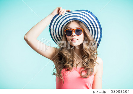Beautiful girl in a summer hat and sunglasses 58003104