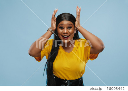 African-american young woman's half-length portrait on blue background 58003442
