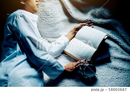 Irritated young woman putting her alarm clock off 58003687