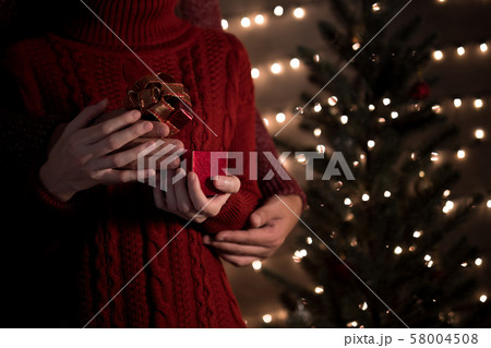 Couple open gifts on Christmas tree lights background at home Couple open gifts on Christmas tree lights background at home 58004508