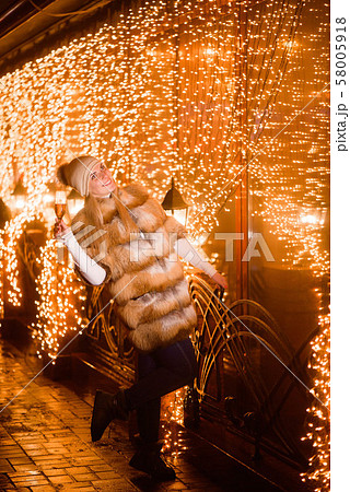 Christmas holiday celebration. Girl drinking champagne over holiday glowing golden background. Christmas holiday celebration. Girl drinking champagne over holiday glowing golden background. 58005918