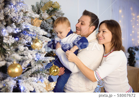 Parent having fun together near Christmas tree. 58007672