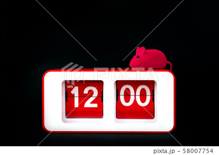 A red rectangular clock on a black background and a small toy rat 58007754